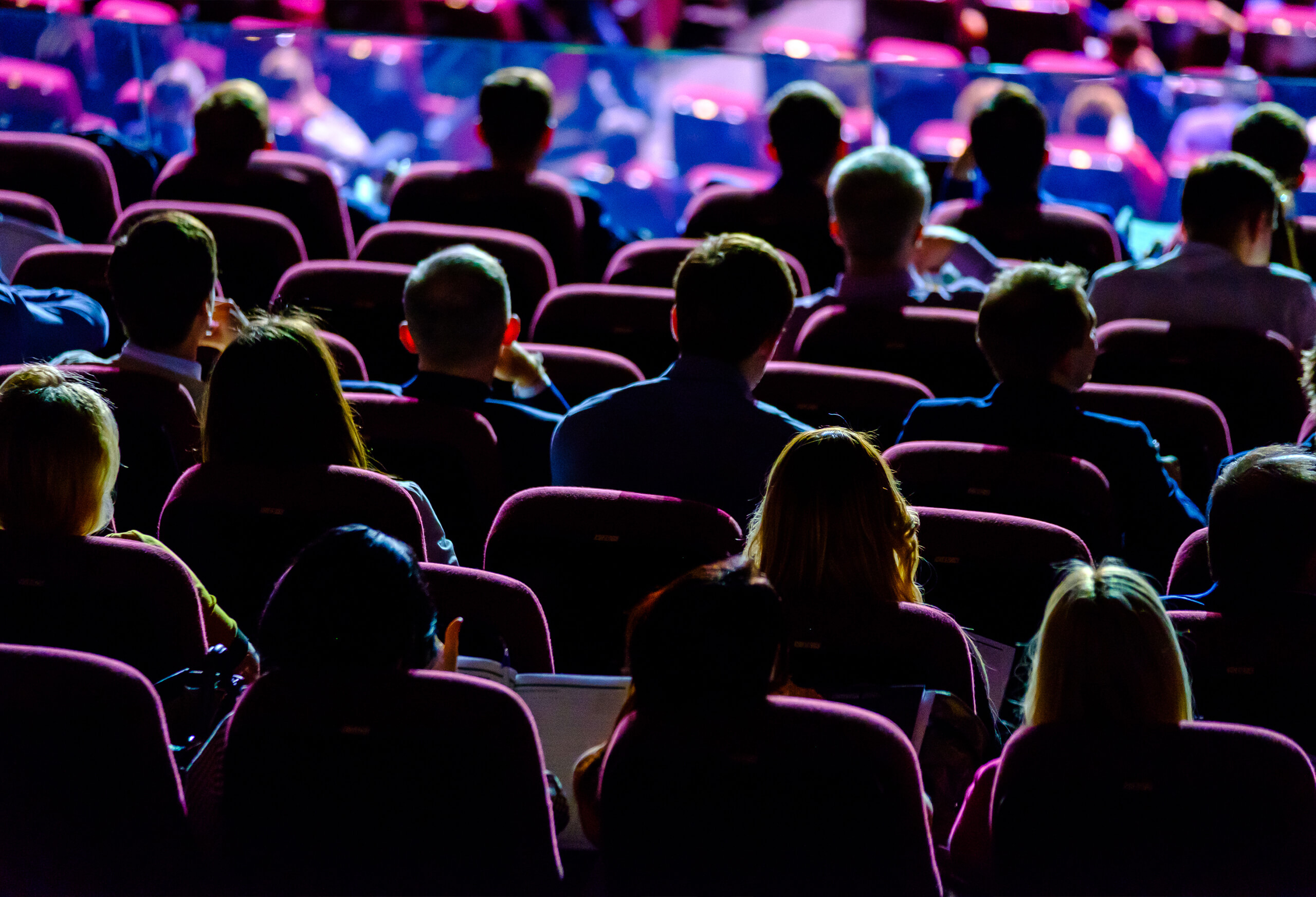 Crowd sitting at tradeshow with multi-color lighting