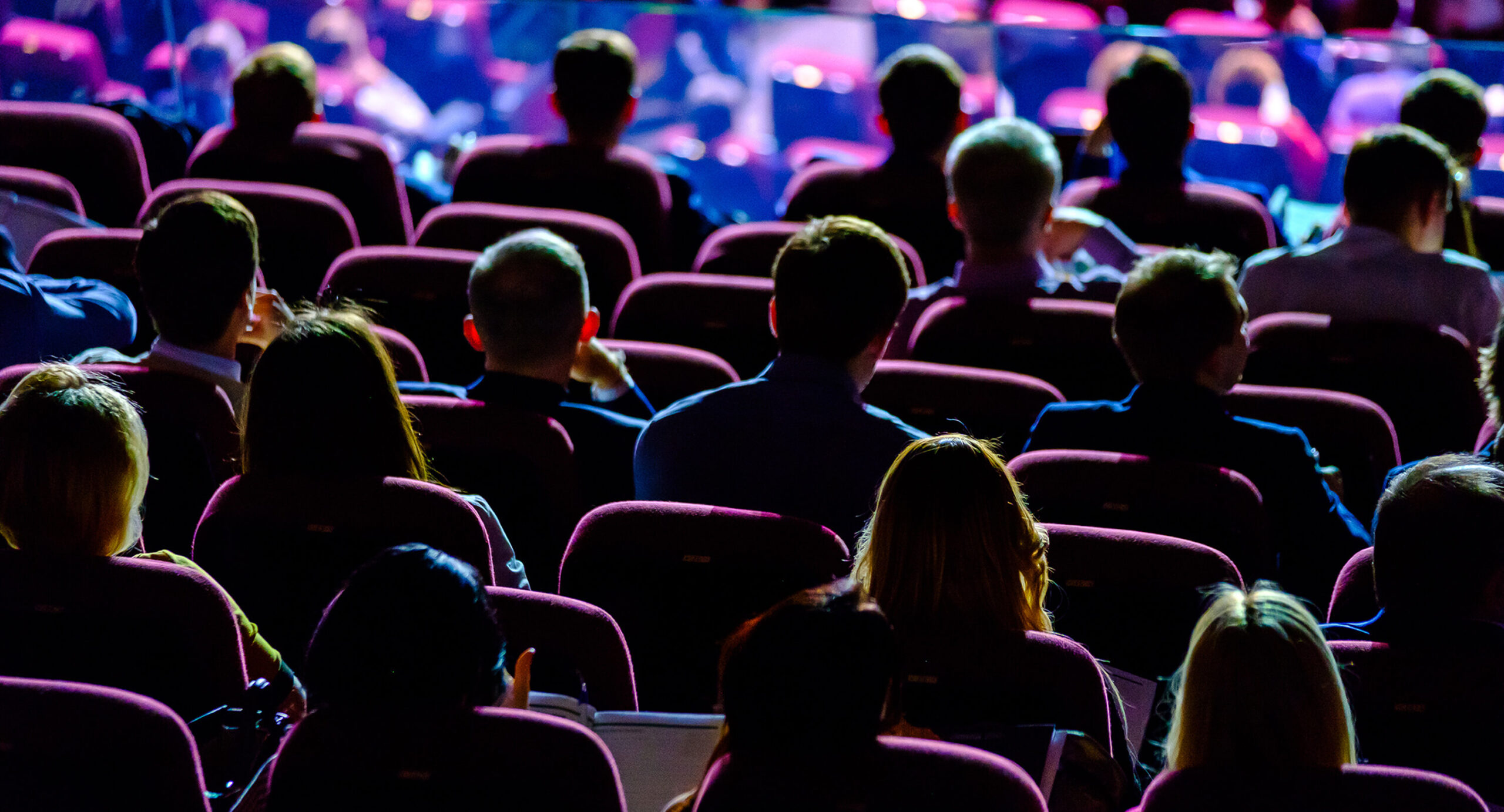 Crowd sitting at tradeshow with multi-color lighting